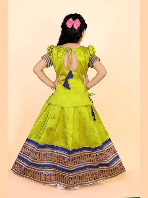 Green dress with a patterned skirt worn by a person on a beige background